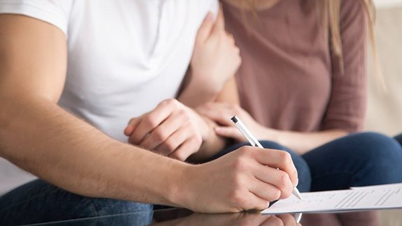 Junges Paar unterschreibt Mietvertrag